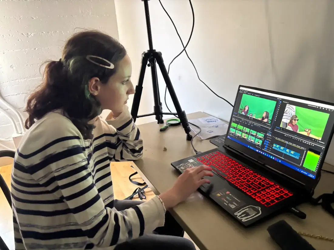 Teen video editing at film camp — cutting her crew’s green-screen footage on a real timeline