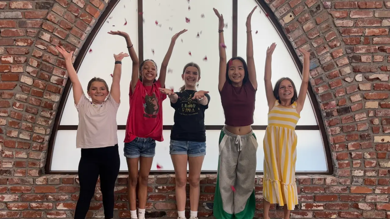 Campers shooting a falling-petals scene on set at a filmmaking camp for kids
