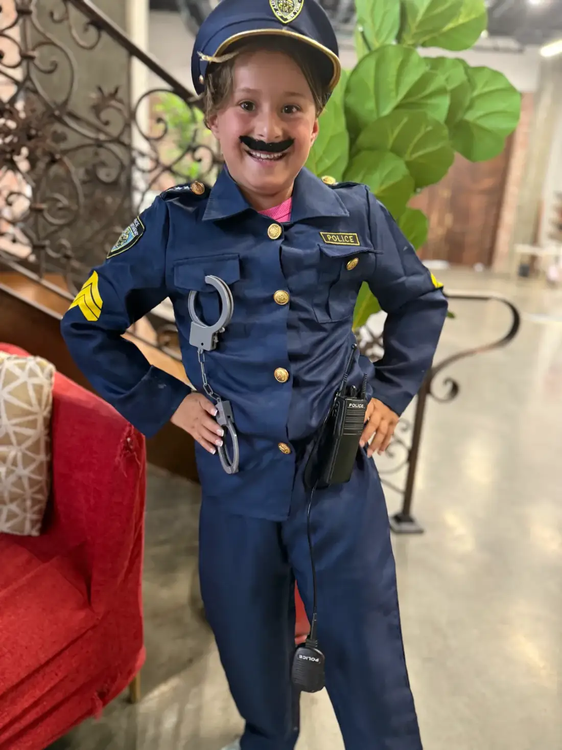 A young actor in a police costume and moustache, in character