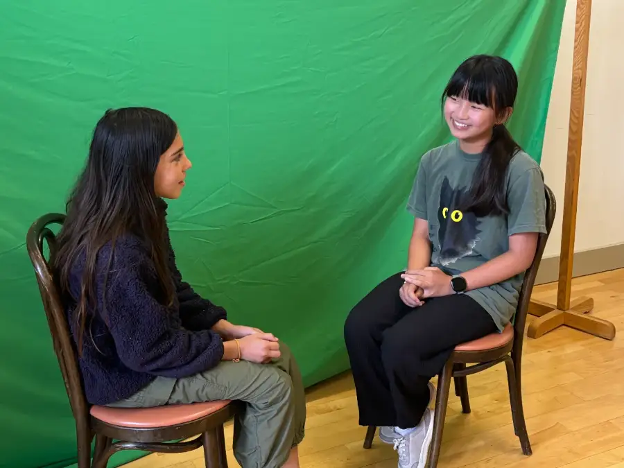 Two campers running an interview scene against the green screen