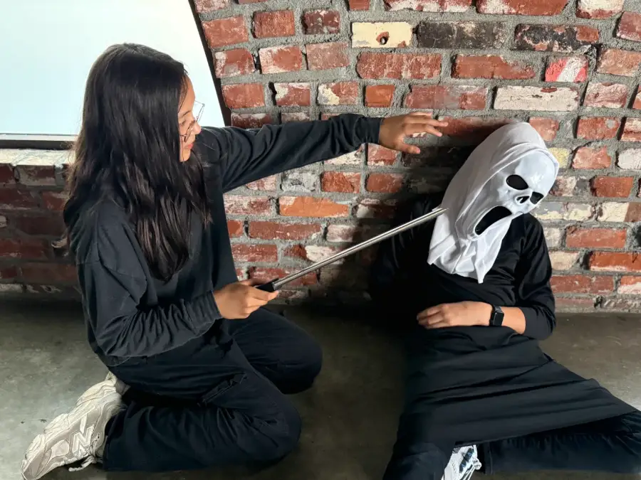 Two campers staging a stunt against the brick wall